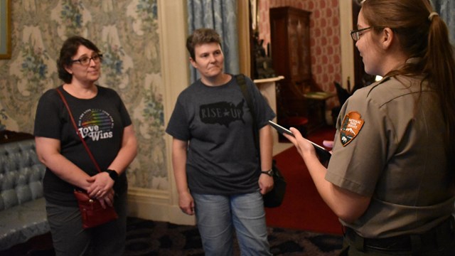 Ranger talking with visitors in the birthplace