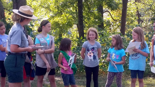 Ranger talking to Girl Scouts in the woods