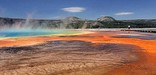 Steam rises above the beautiful browns, oranges, and blue colors of Grand Prismatic Spring.