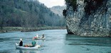 Canoeists float near large cliff