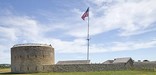 The US flag waves over the round tower of the Historic Fort Snelling.