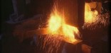 Bright orange sparks are scattered under the crashing blow of the forge's five hundred pound hammer.