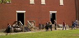 A tour in front of the enormous brick facade of the Public Stores. NPS Photo.