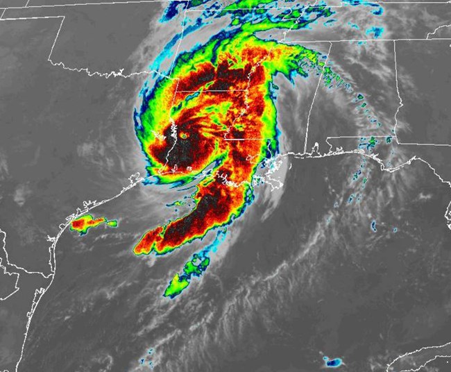 infrared satellite image showing shades of black, red, yellow, and blue swirling above a map of Texas and Louisiana