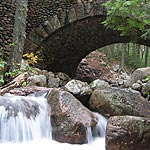 Water rushes over a small waterfall underneath Cobblestone Bridge.