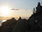 Man on rocks silhouetted against sunset