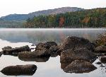 Rocks in lake with fall colors in background