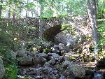 Cobblestone-faced bridge in evergreen forest