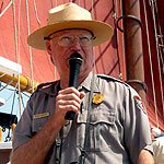 A park ranger uses a microphone to narrate on a ship.