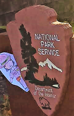 Paper cut out of ranger on wooden national park sign