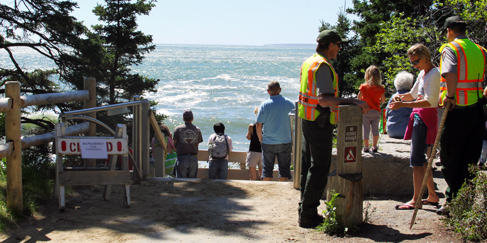 Law Enforcement Rangers assist visitors at Sand Beach while viewing the surf during Hurricane Irene, 2011.