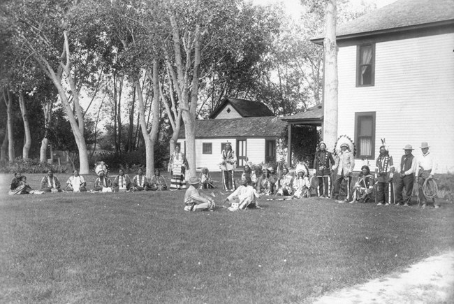 A meeting between James Cook and Jack Red Cloud on the lawn in front of the ranch house.
