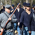 Living historians portraying prisoners and a guard