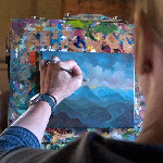 Woman painting landscape on small canvas
