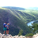 Hikers atop a mountain looking down at the river