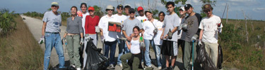 Florida International University Students collecting trash in a sawgrass prairie