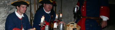 Spanish soldiers relax at thier rough hewn barracks table for a meal.