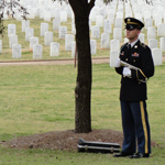 A member of an Army honor guard stands ready to sound taps