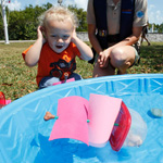 A young visitor watches his boat topple without ballast.