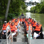 Image of people in an open boat going down a bayou