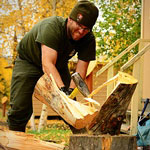 A Ranger splitting wood for public use cabins