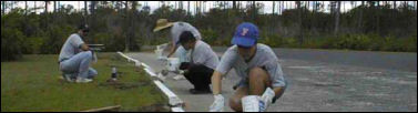 Volunteer Group Painting Parking Lot Bumpers in Campground