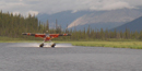 A float plane landing on a lake in the park. A float plane landing on a lake in the park.