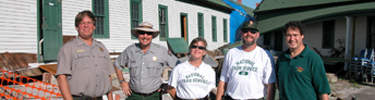 Employees stand outside a historic building at Fort Pickens.