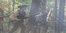 Man in woods with rifle Man in woods with rifle