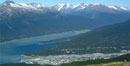 Aerial Photo of Skagway showing the blue waters of the Taiya Inlet, snow-capped peaks and the little town dwarfed in the foreground Aerial Photo of Skagway showing the blue waters of the Taiya Inlet, snow-capped peaks and the little town dwarfed in the foreground