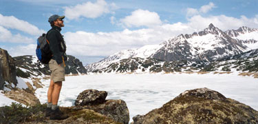 hiker enjoying the snow covered scene at Crater Lake above timberline