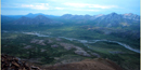 The Noatak River winds its way through a verdant tundra valley ringed by steep grey mountains. The Noatak River winds its way through a verdant tundra valley ringed by steep grey mountains.