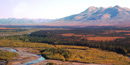 Mountains and tundra blush with autumn colors, contrasting with the dark evergreens. Mountains and tundra blush with autumn colors, contrasting with the dark evergreens.
