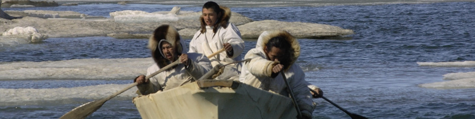 Three Iñupiat men paddling a whaling boat