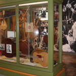 Image of exhibit case filled with guitars and other instruments