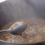 Image of a spoon stirring a pot of gumbo
