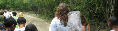 NPS Ranger Laurel carries a net while leading students to a seashore field trip.