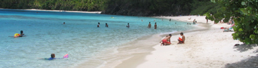 Visitors enjoying the clear blue water at the beach at Hawknest.