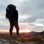 A hiker on a peak at sunset