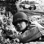 An American GI takes cover from Japanese snipers on Attu, May 1943.
