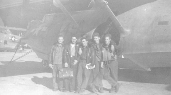 Crewmembers stand in front of their plane