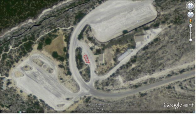 Aerial photo of Pecos parking areas with road arcing up from the lower part of image between two large parking areas. Demonstration area is a small rectangle, outlined in red, inside of a loop within the arcing road.