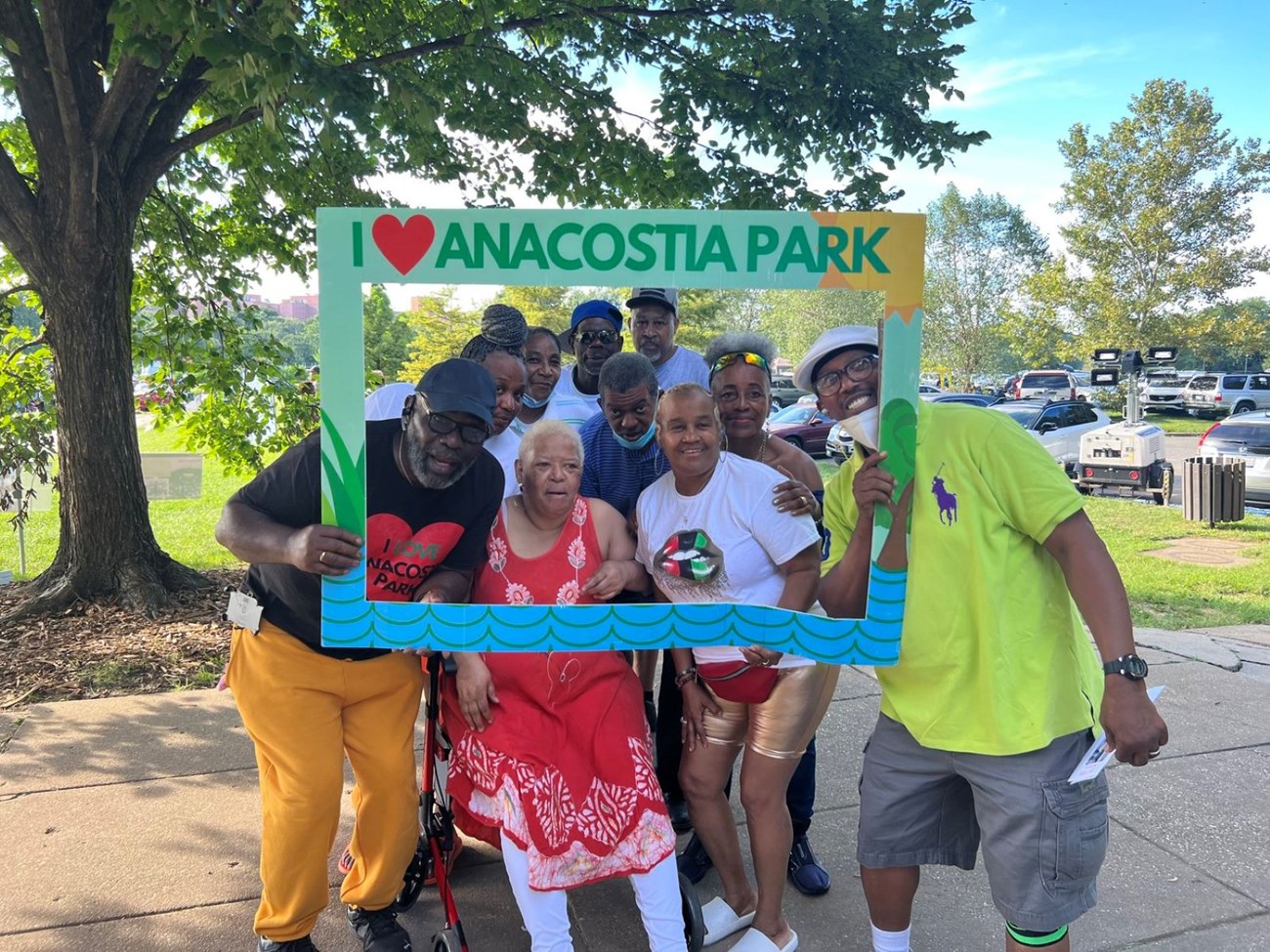 People come together for a picture with an I Love Anacostia Park Sign