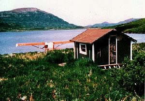 A picture of a cabin and a float plane on Kodiak island