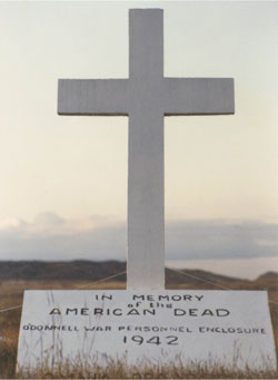 White monument made of cement and featuring a cross