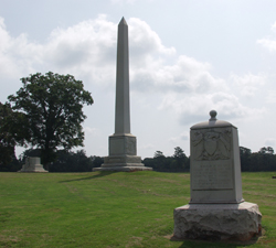 Three stone monuments on a grassy field