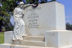 Stone monument with a female figure holding a wreath