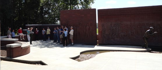 A park ranger speaks to visitors in a brick lines courtyard space