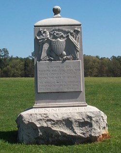 A stone monument with the Union Shield in a grassy filed