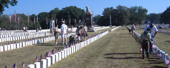 Scouts and leaders placing flags in the National Cemetery